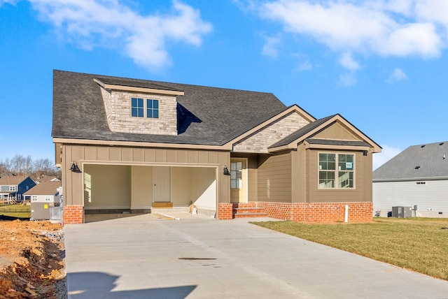 view of front facade featuring a front yard, driveway, stone siding, board and batten siding, and brick siding