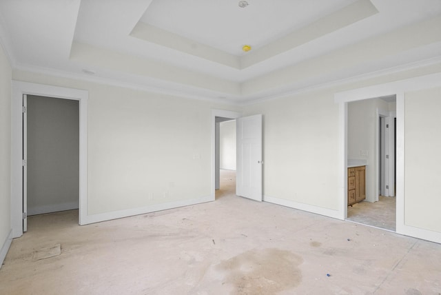 unfurnished bedroom featuring baseboards, a raised ceiling, and crown molding