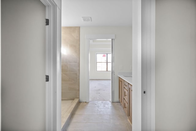 full bath featuring vanity, visible vents, and tiled shower