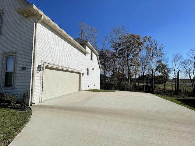 view of side of property with brick siding and concrete driveway