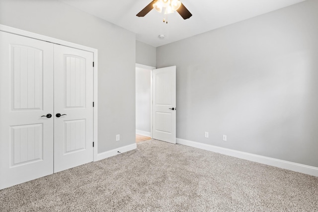 unfurnished bedroom featuring a closet, baseboards, carpet, and a ceiling fan