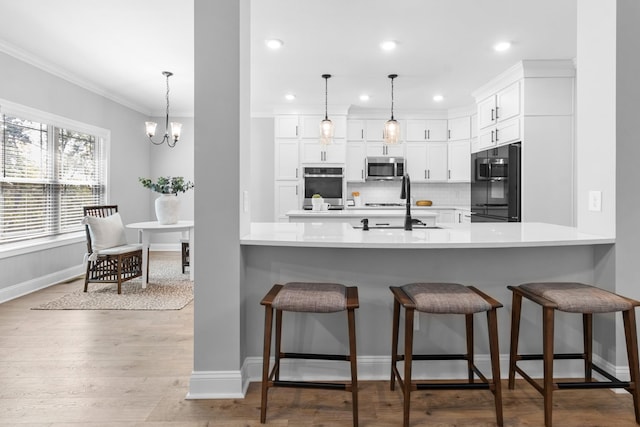 kitchen featuring stainless steel microwave, refrigerator, a breakfast bar, and light countertops