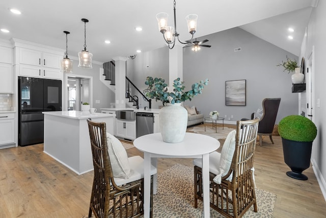 dining space featuring a ceiling fan, recessed lighting, light wood finished floors, lofted ceiling, and stairs