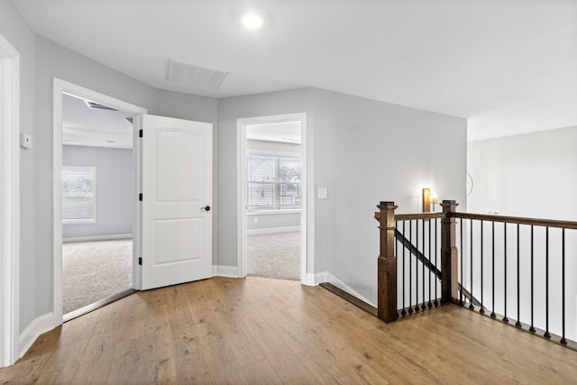 bonus room featuring visible vents, baseboards, light wood-style floors, and a healthy amount of sunlight