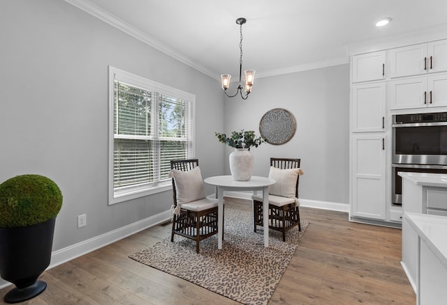 dining room with baseboards, light wood finished floors, recessed lighting, crown molding, and a notable chandelier