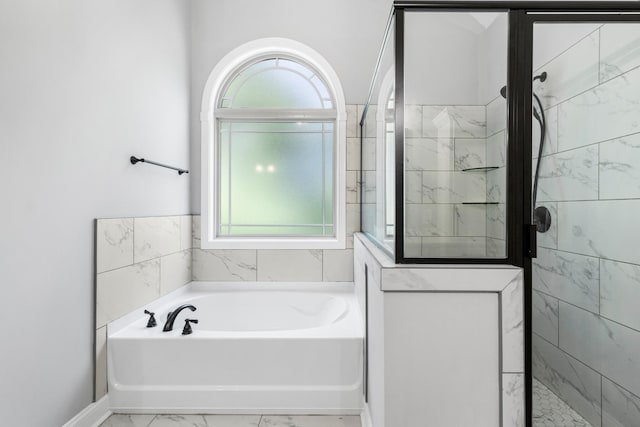 bathroom featuring a bath, marble finish floor, and a stall shower