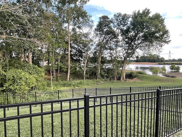 view of yard featuring a water view and fence