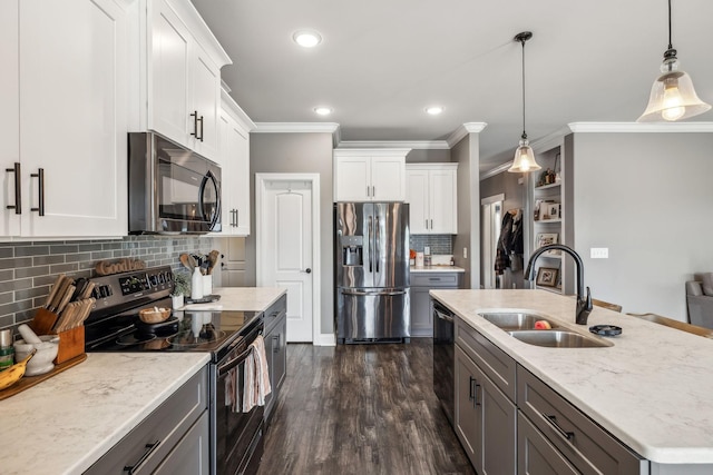 kitchen featuring dark wood finished floors, hanging light fixtures, white cabinets, black appliances, and a sink