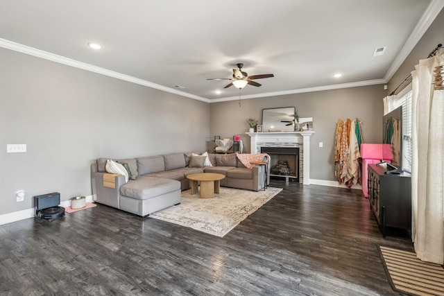 living area featuring visible vents, ornamental molding, dark wood finished floors, a fireplace, and baseboards