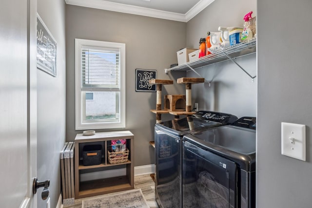 laundry room with radiator, wood finished floors, washing machine and clothes dryer, laundry area, and ornamental molding