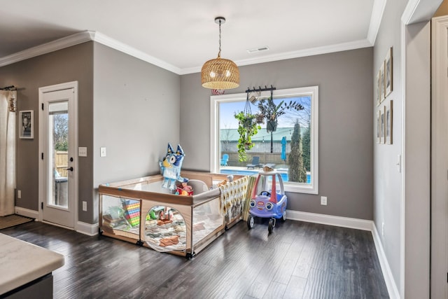 interior space with dark wood finished floors, visible vents, a wealth of natural light, and ornamental molding