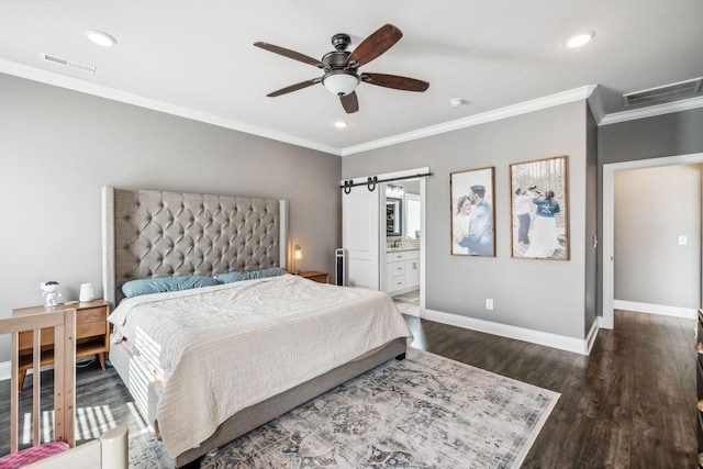 bedroom featuring visible vents, a barn door, baseboards, and wood finished floors