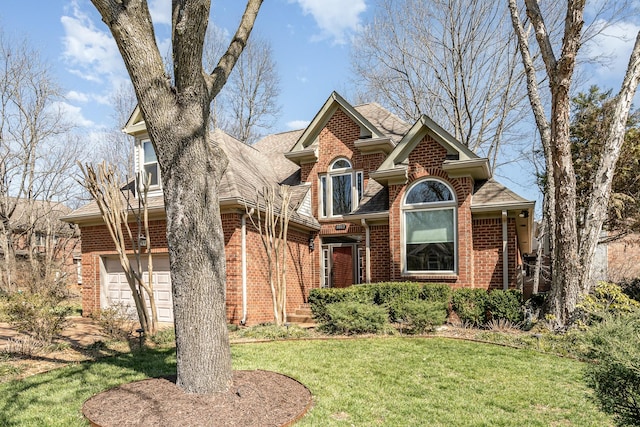 view of front of home featuring brick siding, an attached garage, a front yard, and a shingled roof