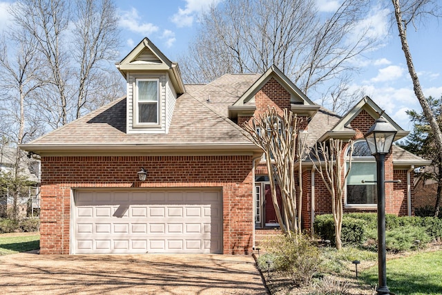 view of front facade with brick siding, an attached garage, driveway, and roof with shingles