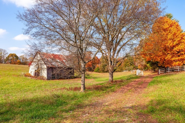 view of yard with an outbuilding, a barn, and fence