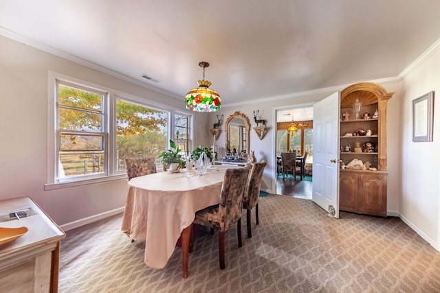 carpeted dining room featuring visible vents, baseboards, and ornamental molding