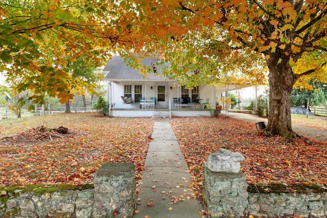 view of front of property with covered porch and fence