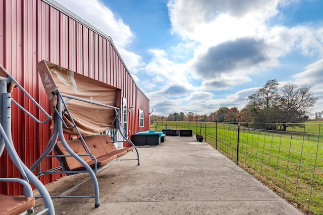 view of patio with an outbuilding and a rural view