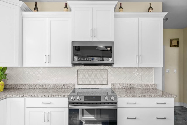 kitchen with light stone counters, tasteful backsplash, appliances with stainless steel finishes, and white cabinetry