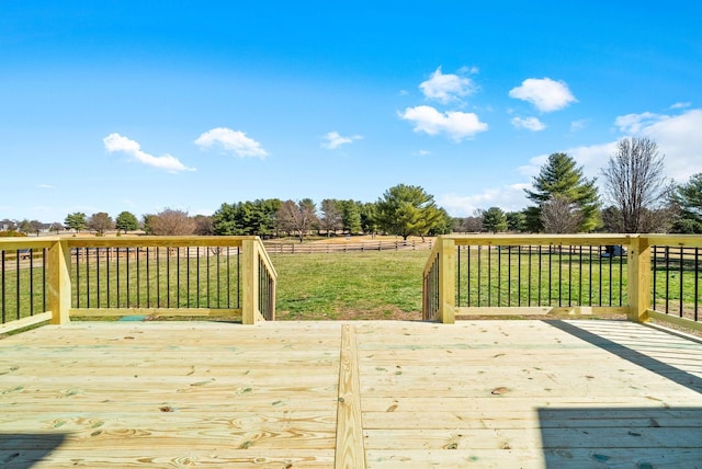 wooden terrace featuring a yard and a rural view