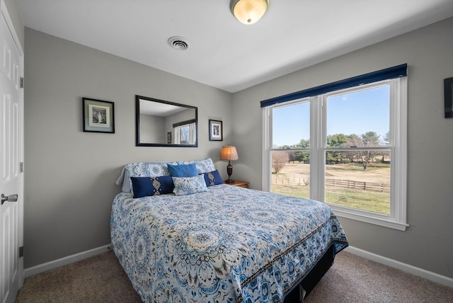 carpeted bedroom with visible vents and baseboards