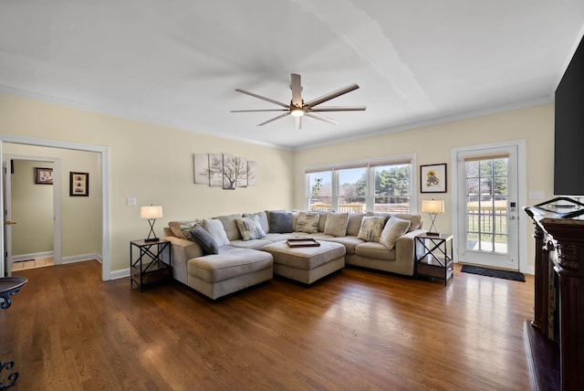 living area with dark wood-style floors, baseboards, and ceiling fan