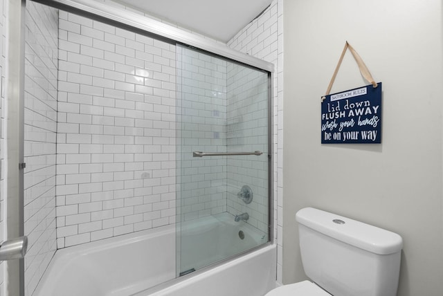 bathroom with toilet and shower / bath combination with glass door