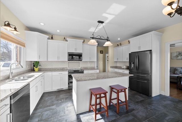 kitchen with a sink, a center island, tasteful backsplash, and stainless steel appliances