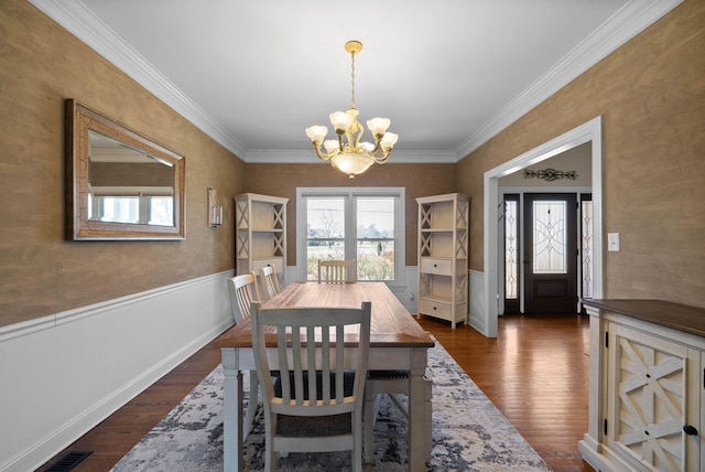 dining room featuring a wainscoted wall, dark wood-type flooring, a notable chandelier, and visible vents