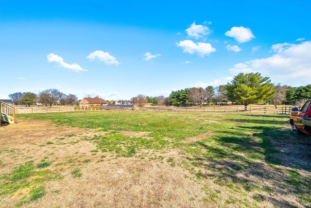 view of yard with a rural view and fence