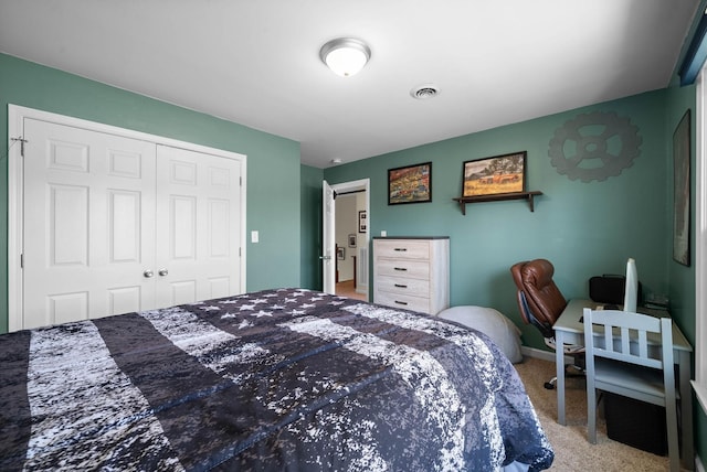 carpeted bedroom featuring a closet and visible vents