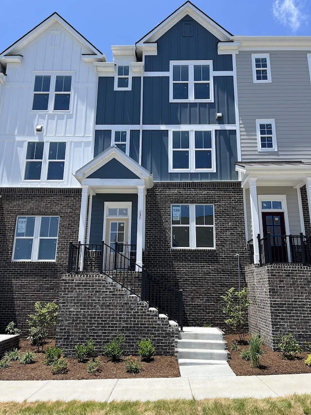 view of front of home featuring brick siding and board and batten siding