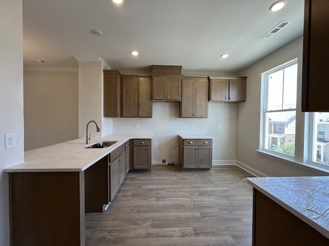 kitchen featuring a sink, visible vents, recessed lighting, and light wood finished floors