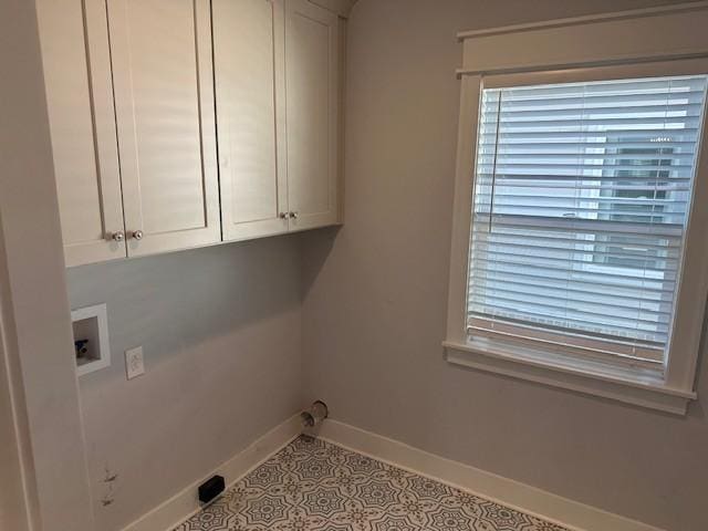 laundry room featuring tile patterned floors, baseboards, washer hookup, and cabinet space