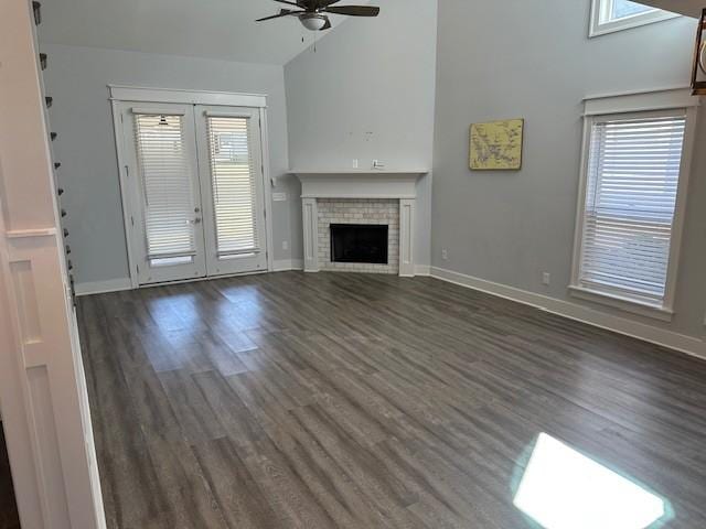 unfurnished living room with a fireplace, a ceiling fan, wood finished floors, and high vaulted ceiling