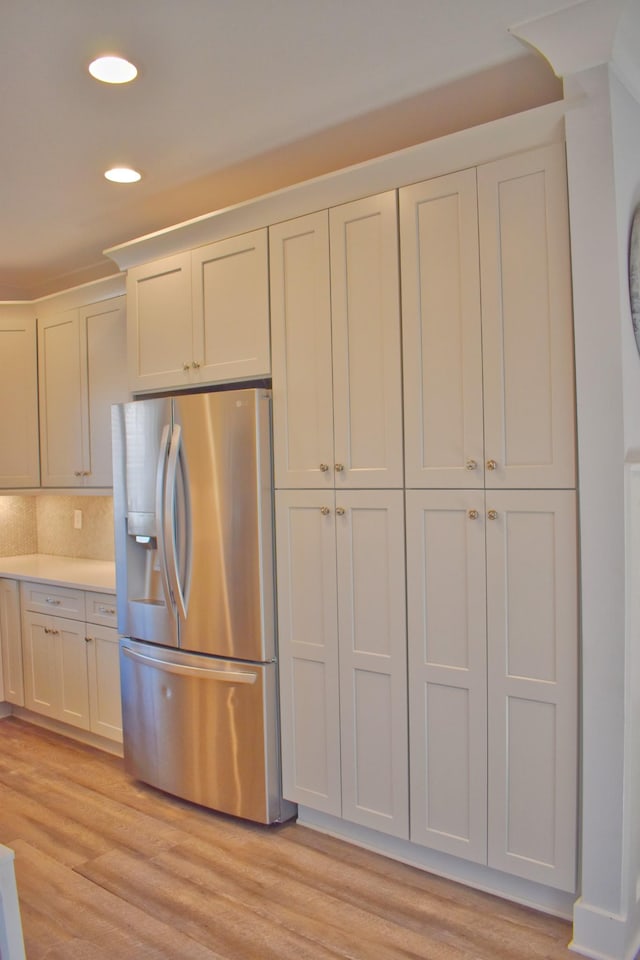 kitchen featuring recessed lighting, light wood-style flooring, light countertops, and stainless steel refrigerator with ice dispenser