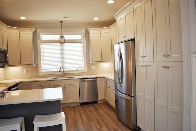 kitchen featuring dark wood-type flooring, light countertops, appliances with stainless steel finishes, and a sink