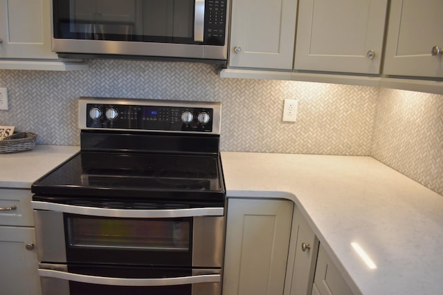 kitchen with light countertops, gray cabinets, backsplash, and stainless steel appliances