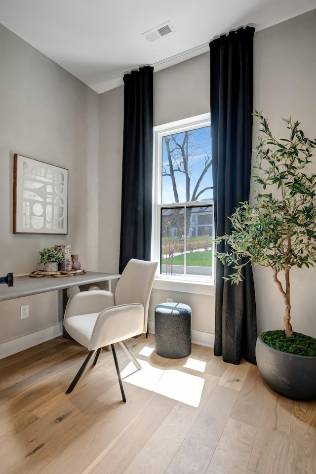 office area featuring baseboards, visible vents, and light wood-type flooring