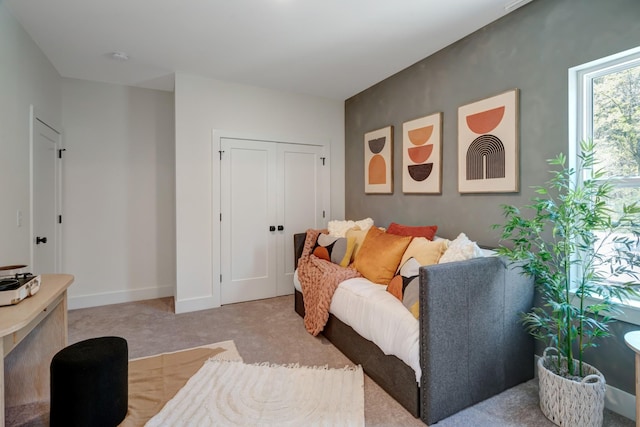 living area featuring light carpet and baseboards