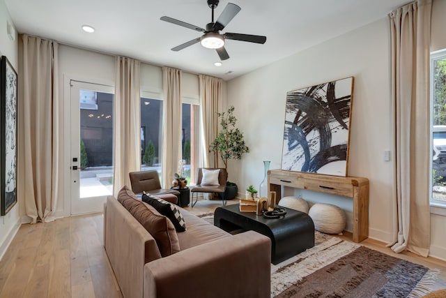 living area featuring baseboards, recessed lighting, light wood-type flooring, and ceiling fan