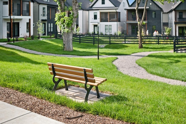 view of community featuring a residential view, a lawn, and fence