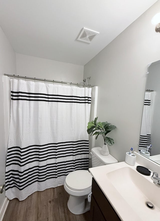 full bathroom featuring vanity, wood finished floors, visible vents, curtained shower, and toilet