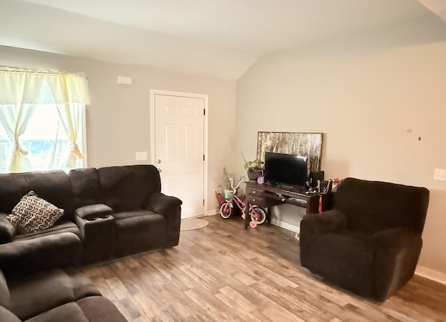 living area with baseboards, wood finished floors, and vaulted ceiling