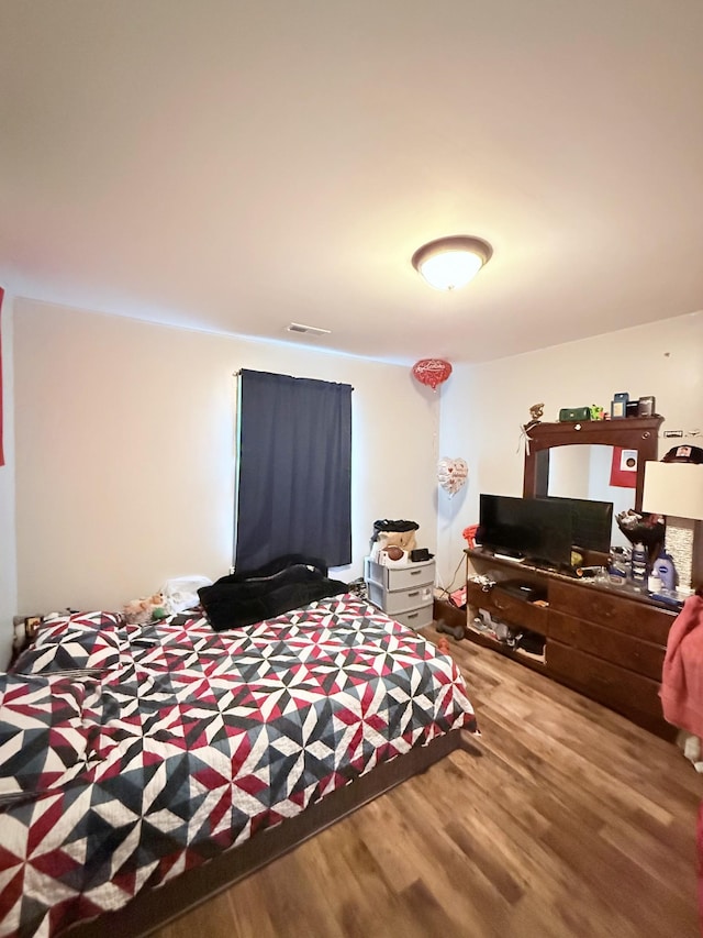 bedroom featuring visible vents and wood finished floors