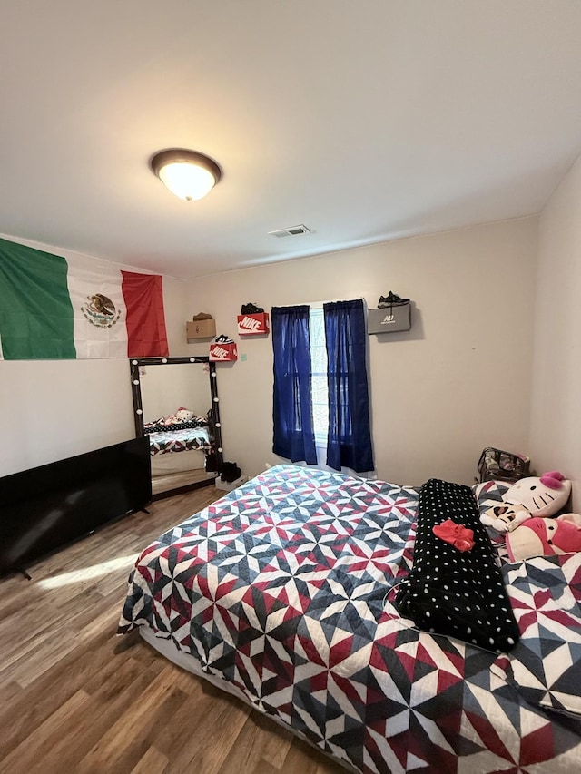 bedroom with visible vents and wood finished floors