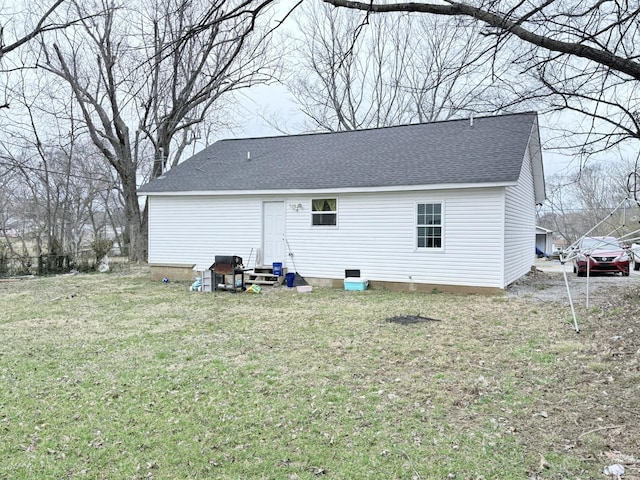 rear view of house with a lawn and a shingled roof