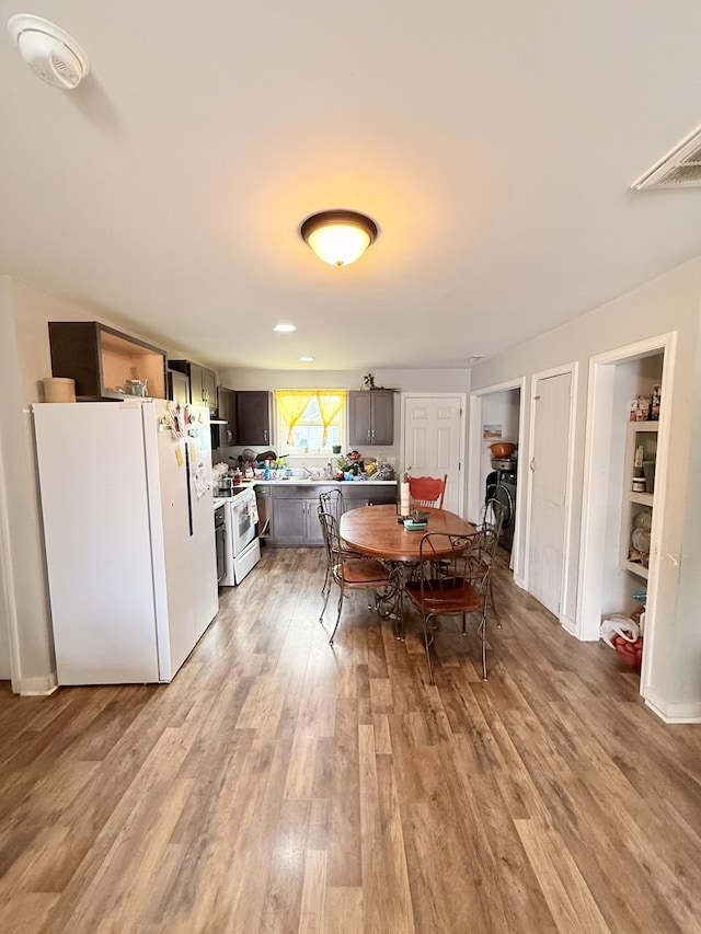 dining area featuring light wood-style flooring and visible vents