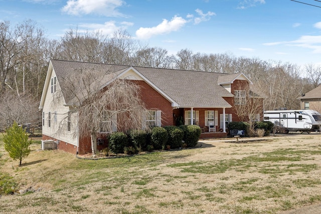 cape cod-style house featuring central AC unit, a front yard, and roof with shingles