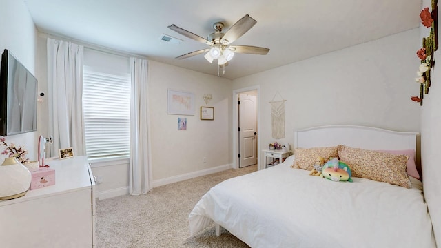 bedroom featuring visible vents, light colored carpet, a ceiling fan, and baseboards